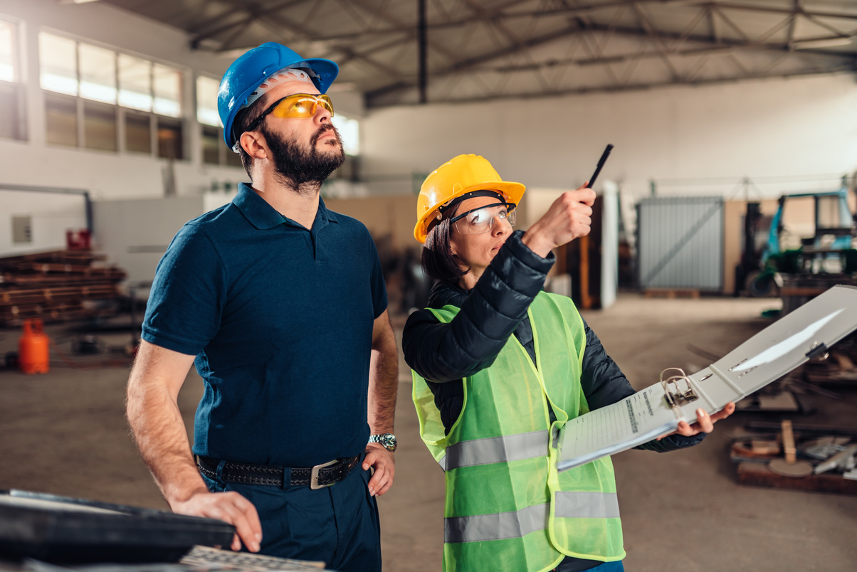 Workplace safety inspector writing a report at industrial factory